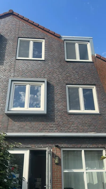 Witte kunststof ramen in een bakstenen gevel